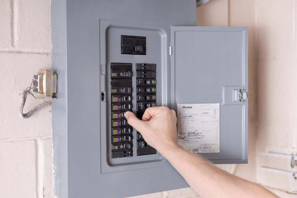 Electrician inspecting an electrical panel for safety and performance in a Carol Stream home.
