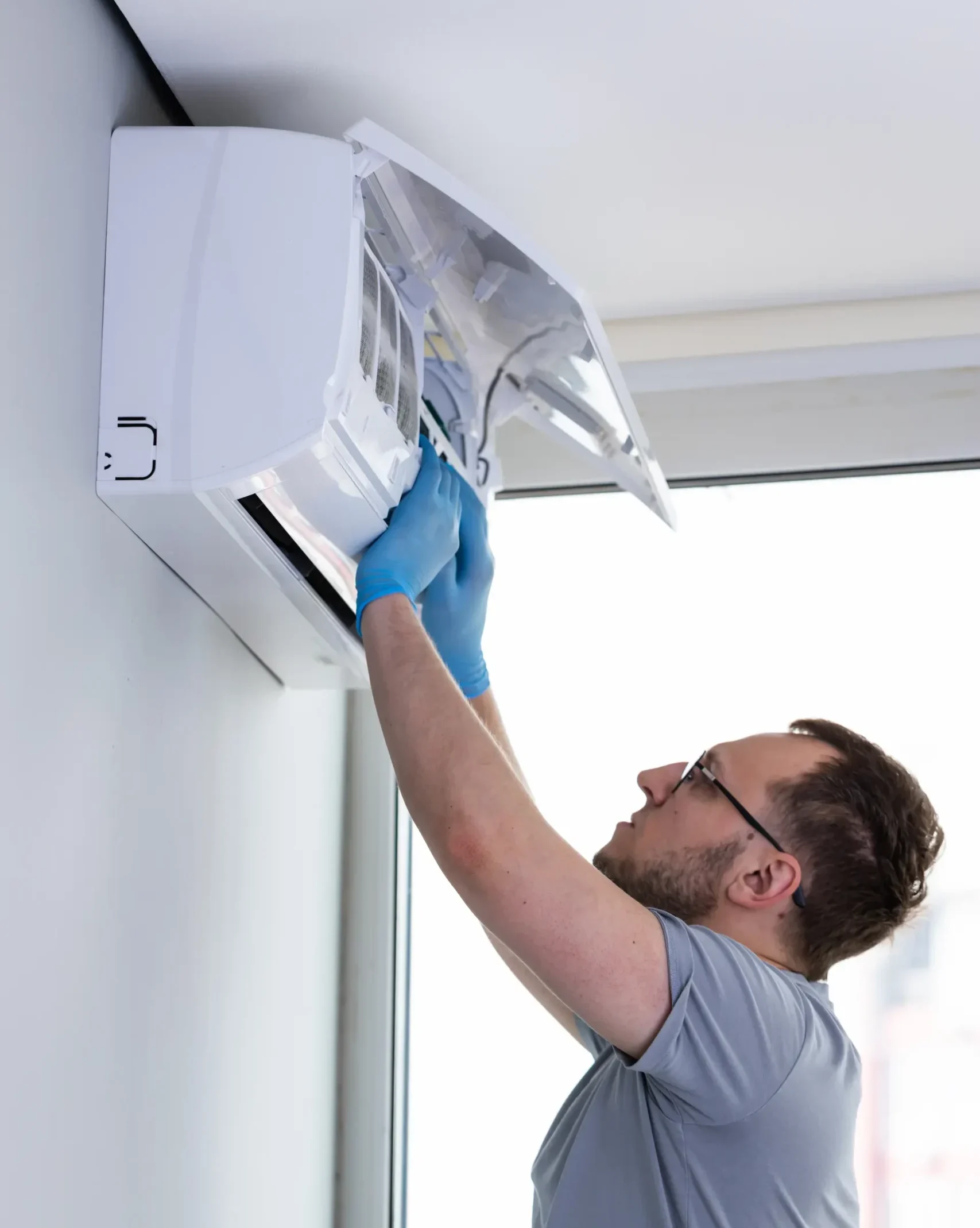 Technician performing maintenance on Ductless AC Unit