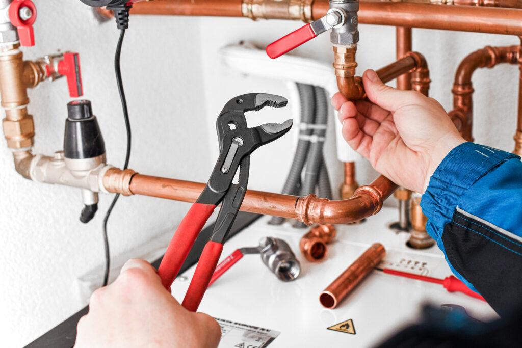 Plumber working on copper water piping and valves