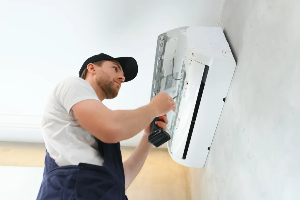 Technician is cleaning and repairing Air Conditioner