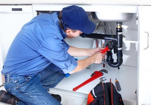 plumber working on drains plumbing